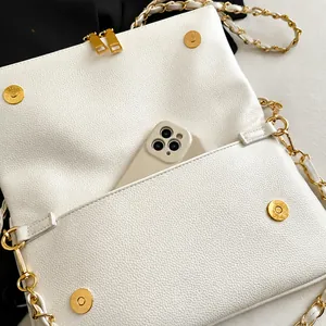 Macro detail of white lychee leather handbag interior with phone pocket and gold chain strap