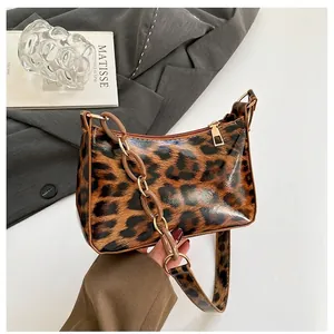 Détail du sac à main léopard tendance avec fini verni et sangle à grosse chaîne