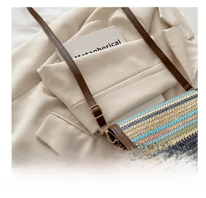 Detail of colorful woven shoulder bag featuring textured chevron patterns and brown leather strap