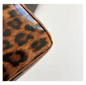 Gros plan sur le motif léopard brillant avec passepoil en cuir marron de haute qualité