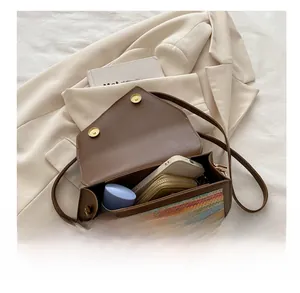 Detailed view of brown flap bag showing internal capacity and colorful woven pattern