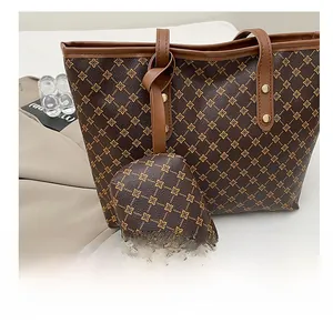 Détail du grand sac cabas marron à motif floral avec rivets dorés et pochette assortie