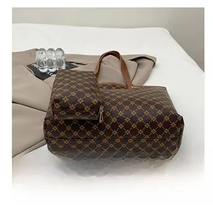 Détails d'un ensemble de cabas marron foncé à monogramme avec pochette assortie
