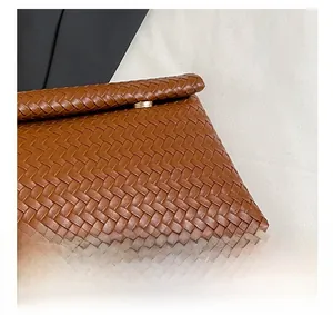Detail shot of brown woven PU leather pouch featuring elegant gold circular hardware