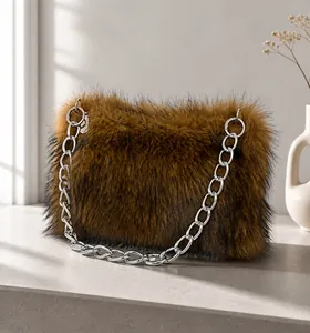 Dettaglio di una borsa in finta pelliccia marrone con catena in metallo argentato
