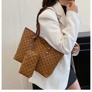Détail du sac cabas marron imprimé avec une pochette assortie et des anses en cuir