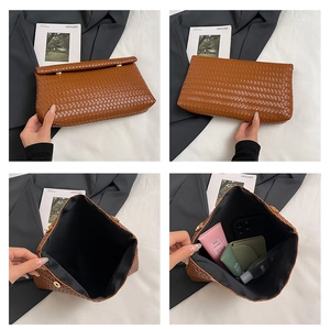 Detail view of brown woven PU leather clutch showing inner lining and magnetic buckle