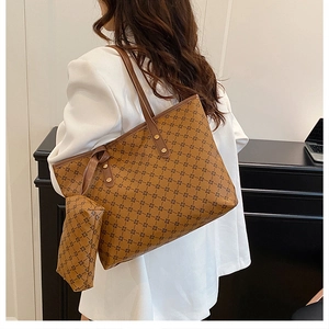 Détail d'un grand sac cabas marron à motifs avec pochette sur modèle en blazer blanc