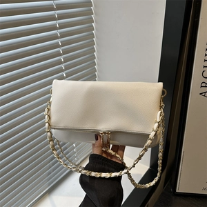 Bolso con solapa blanco crema con textura de lichi y cadena dorada en la mano