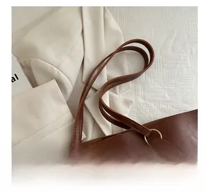 Detail of brown leather tote bag with fine texture and golden ring hardware buckle