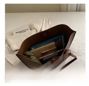 Internal view of dark brown leather tote bag showing large capacity and magnetic clasp