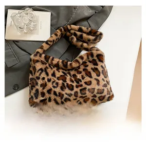 Vue détaillée d'un sac à main léopard en fausse fourrure à côté d'un smartphone pour la taille