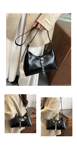 Detail view of black glossy patent leather shoulder bag with silver rivet strap and zipper