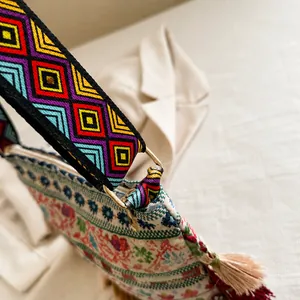Macro detail of bohemian woven bag with golden metal ring and colorful geometric strap