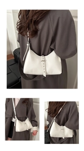 Detailed view of minimalist white leather underarm bag with decorative belt buckle strap