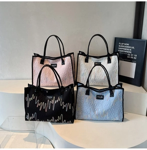 Detail of multi-color quilted tote bags with zigzag embroidery and black shoulder straps