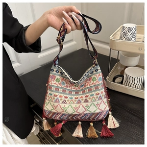 Detail of colorful Bohemian embroidery and fringe tassels on a woven crossbody shoulder bag