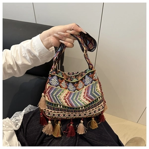 Detail of bohemian handbag featuring colorful ethnic embroidery and layered fringe tassels