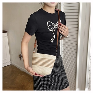 Détail de la texture en paille naturelle et des rayures brunes sur le sac seau