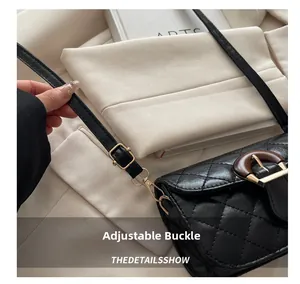 Detail of adjustable strap buckle and wood-pattern buckle on black quilted leather bag
