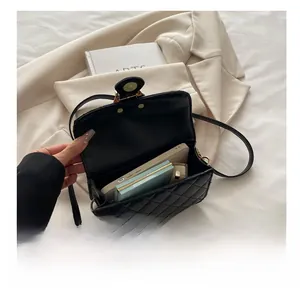 Detail view of black quilted chain bag interior showing phone and makeup storage space