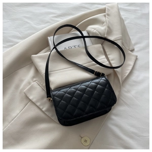 Close-up of quilted black leather texture with fine stitching on a mini crossbody bag