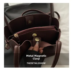Close-up of leather bucket bag interior with magnetic snap and zipper compartments