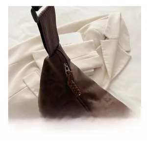 Detail of smooth metal zipper and leopard pattern texture on the brown crossbody bag