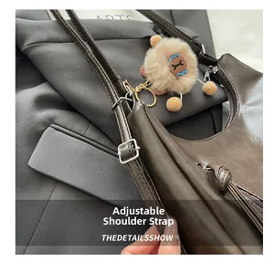 Detail des verstellbaren Schultergurts und der Schnalle einer braunen Vintage-Handtasche