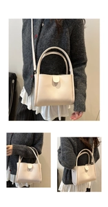 Detail view of the cream-white minimalist bucket bag showing top handles and strap
