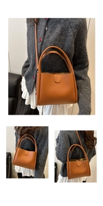 Detail of caramel brown bucket bag with magnetic clasp and double handle structure