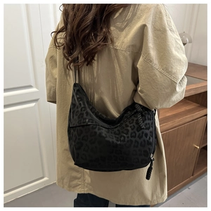 Close-up of leopard print dumpling bag with braided knot zipper and nylon texture