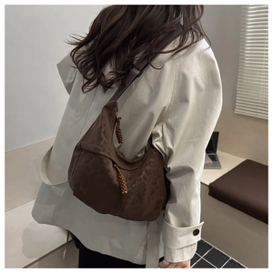 Detail of brown leopard print hobo bag with woven zipper pull on wide shoulder strap