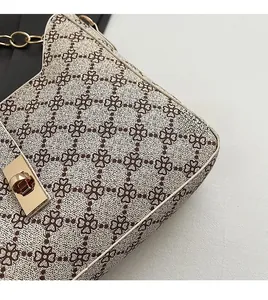 Détail de la texture jacquard rétro et du fermoir métallique doré sur le sac à bandoulière