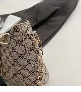 Gros plan sur la chaîne dorée et le motif trèfle vintage du sac à main élégant