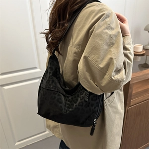 Fashionable black leopard print hobo bag with adjustable strap and smooth animal texture