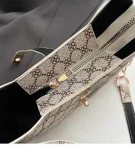 Gros plan sur la fermeture éclair dorée et le motif trèfle sur le sac fourre-tout