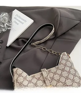 Détail du sac vintage avec bordure en cuir noir et bandoulière en chaîne dorée chic