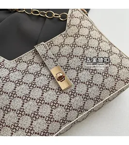 Détail du fermoir doré rotatif et du motif trèfle sur le sac porté épaule rétro chic