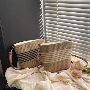 Sacs seaux en paille minimalistes beiges et à rayures noires avec bandoulières en cuir