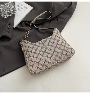 Détail du motif floral luxueux et de la chaîne dorée sur ce sac à main hobo élégant