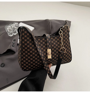 Détail du sac bandoulière marron texturé avec fermoir rotatif doré et accents de chaîne