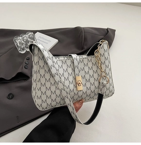 Détail du sac à main monogramme blanc avec fermoir doré et large bandoulière