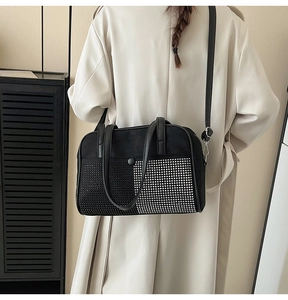 Detail van een zwarte kussentas met strass-mozaïek gedragen door een chic model