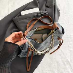 Détail de la grande capacité d'un sac cabas en denim gris avec perles et breloques