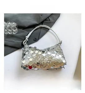 Detailed macro view of silver sequin shoulder bag with stylish knotted handle and metallic finish