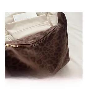 Close-up of leopard print shoulder bag with gold zipper detail and fuzzy texture