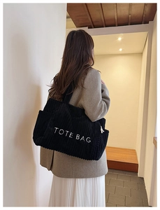 Modellansicht der großen schwarzen Cord-Stofftasche mit Stickerei und seitlichem Kordelzug