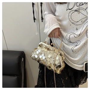 Detail der Pailletten-Abendtasche mit Metallstruktur und goldenem Hohlgriff