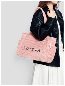 Nahaufnahme der rosa Cord-Tragetasche mit TOTE BAG Stickerei und Kordelzug-Seitentasche